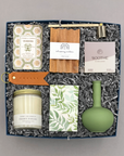 Gift set with candles, soap, and other items in a box on a gray background
