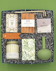 Gift set with candles, soap, and other items on a green background