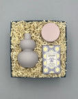 Set of a purple vase, lavender candle, and lavender soap in a box on a gray background