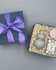 Set of a purple vase, lavender candle, and lavender soap in a box on a gray background