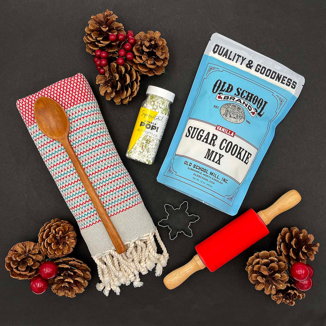 Snowflake cookie cutter, rolling pin, and wood spoon included in the Christmas Cookie baking gift set.