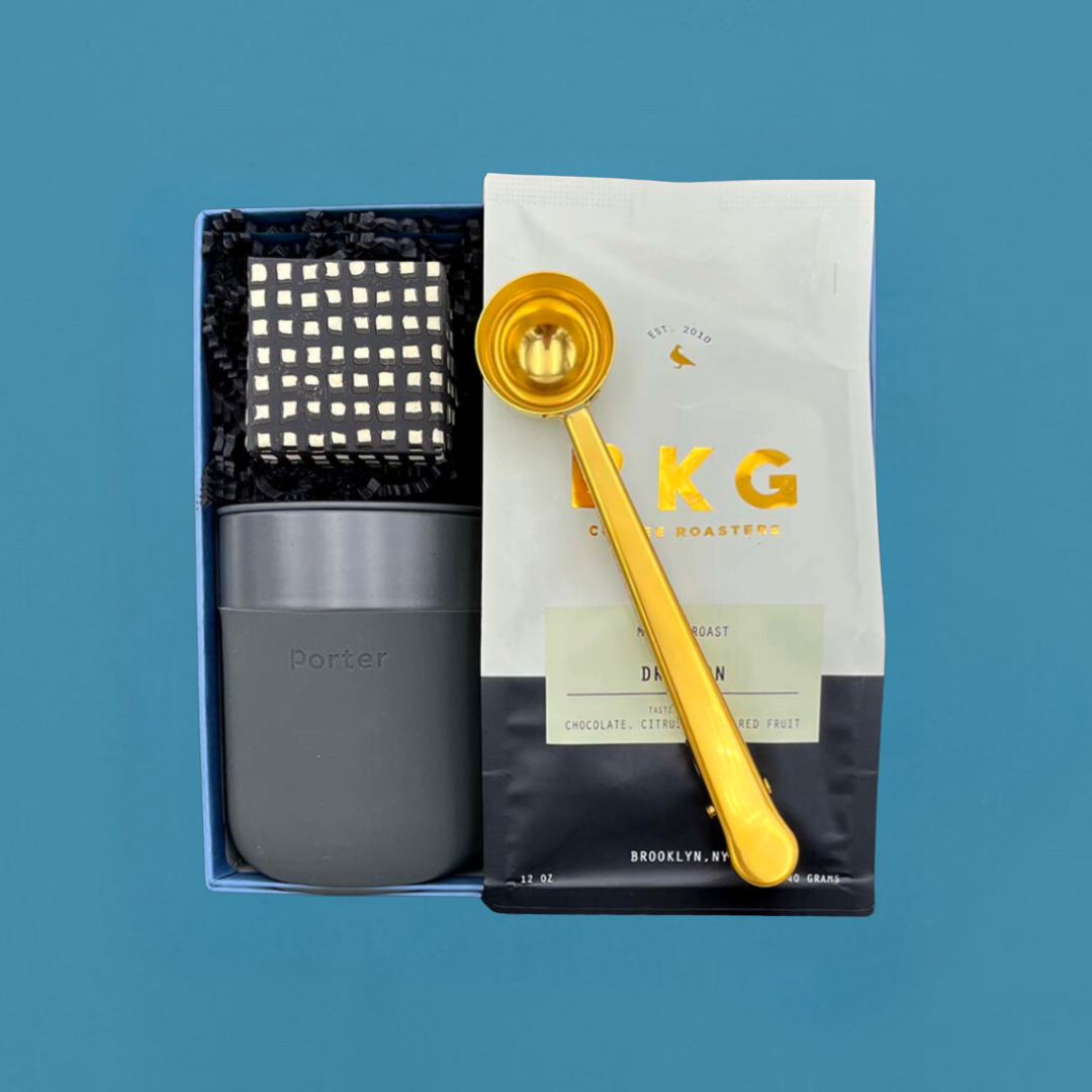Thoughtful gift box for coffee lovers with medium-roast beans, tumbler, sweets, and coffee scoop