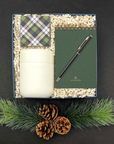 Holiday Good Tidings Gift Box featuring tumbler, green notebook, and chocolate caramels.