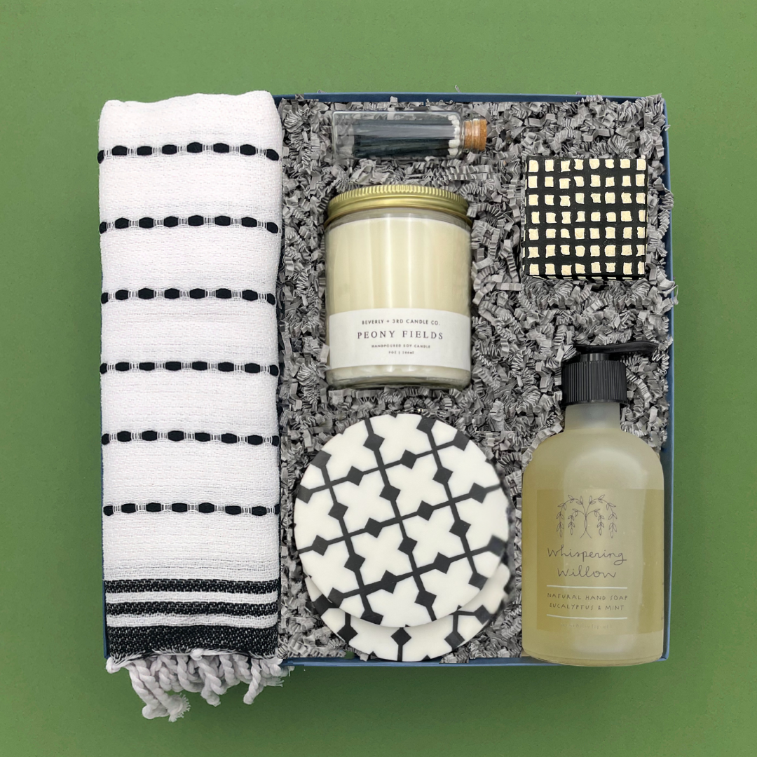 Thoughtful gift for new homeowners with candle, hand towel, soap, coasters, and candy