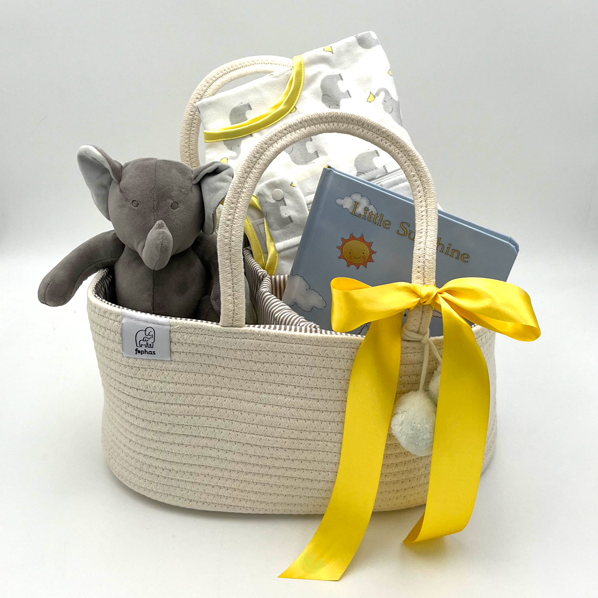 Baby shower gift featuring newborn essentials: blanket, sleep sack, book, and organized diaper caddy