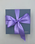 Blue gift box with a purple ribbon on a light gray background
