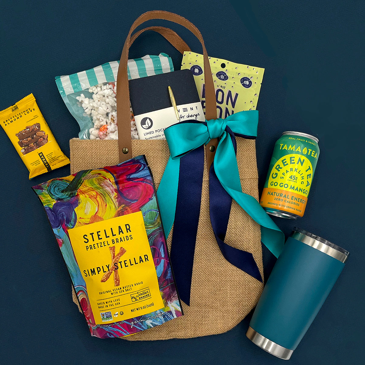 UNCW College Care Package with snacks, a notebook, and a can on a dark blue background