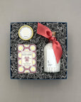 Gift set with a bottle, soap, and decorative items in a box on a gray background