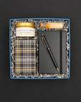 Take Note gift box with black notebook and pen, eucalyptus jasmine candle, gold matches, and gift-wrapped chocolate chip cookies.