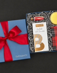 Overhead view of the Warm Wishes Gift Box with hot chocolate, cookies, candle, and peppermint stick matches arranged inside.