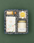 Winter White holiday gift box with Snow & Pine candle, gold matches, butter toffee pretzels, and champagne gummies.