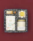 Elegant winter holiday gift with pine candle, gold-tipped matches, sweet and salty pretzels, and champagne-inspired candy.