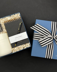 Thoughtful home office gift with notebook, pen, tumbler, and gourmet candy