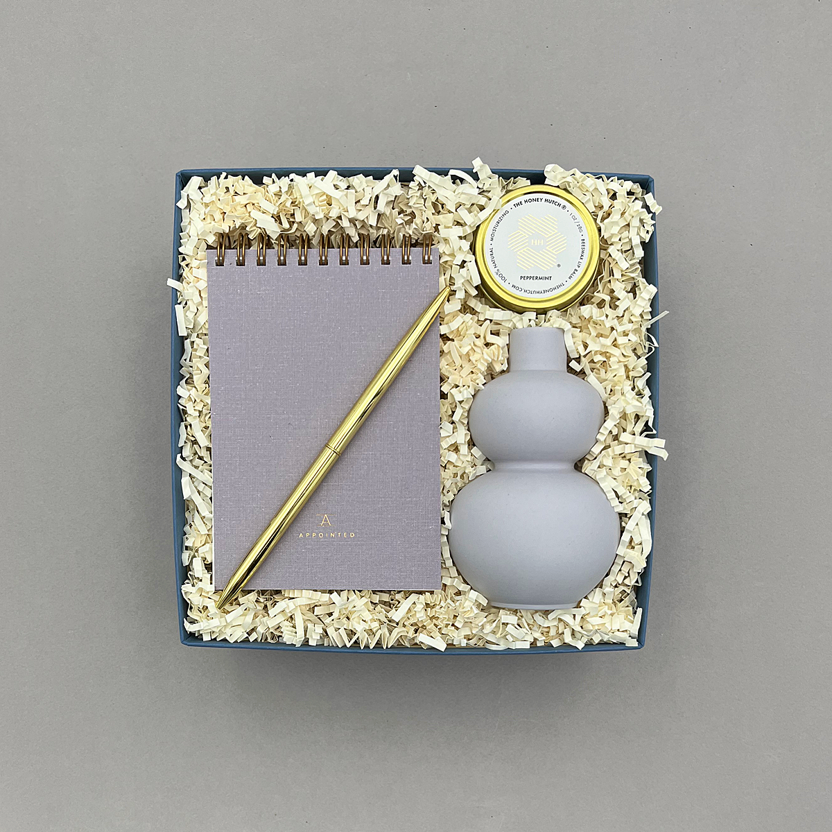 Noted Gift Box with lavender grey pocket notebook, lavender bud vase, lavender lip balm, and gold ballpoint pen