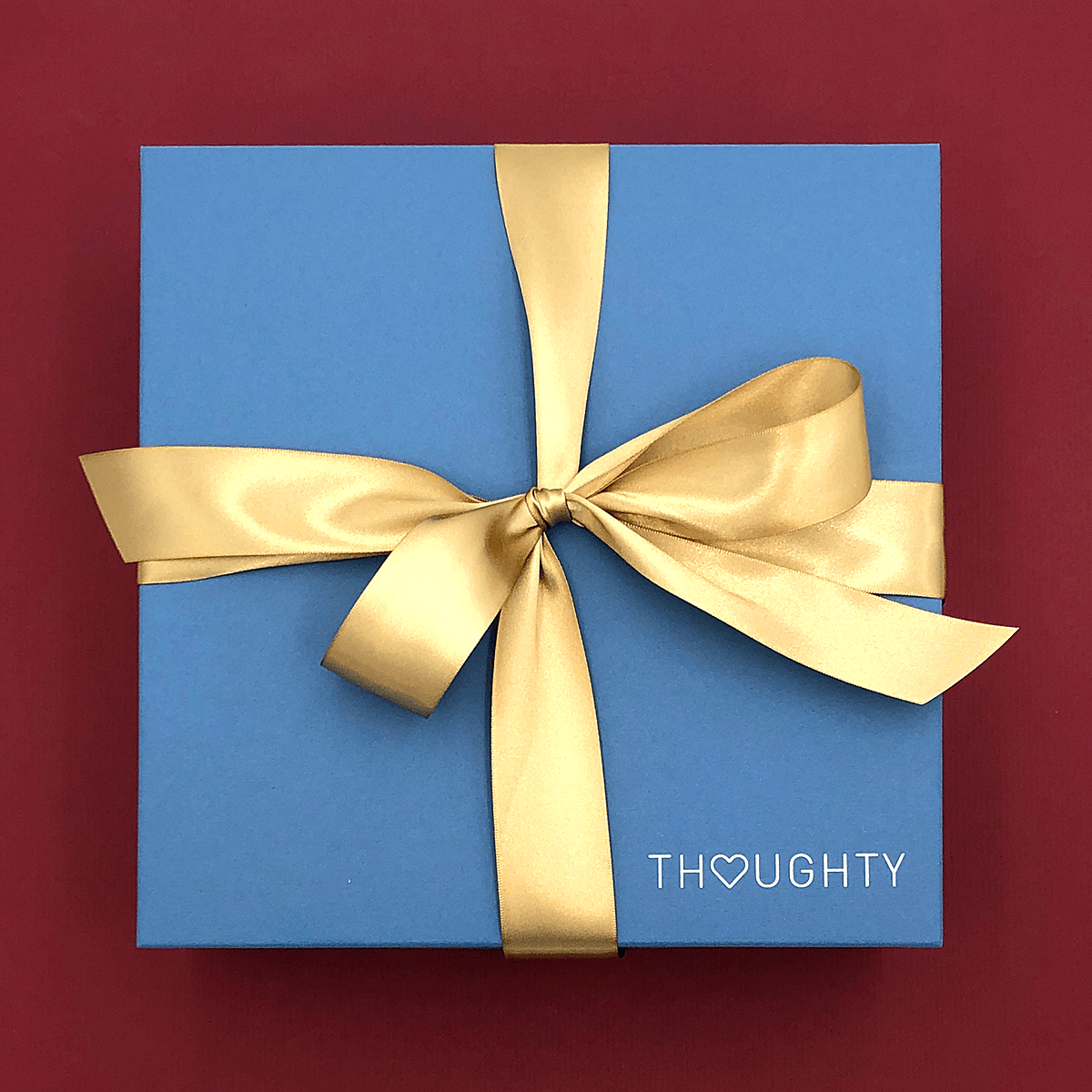 Gift box tied with satin ribbon and handwritten note card.