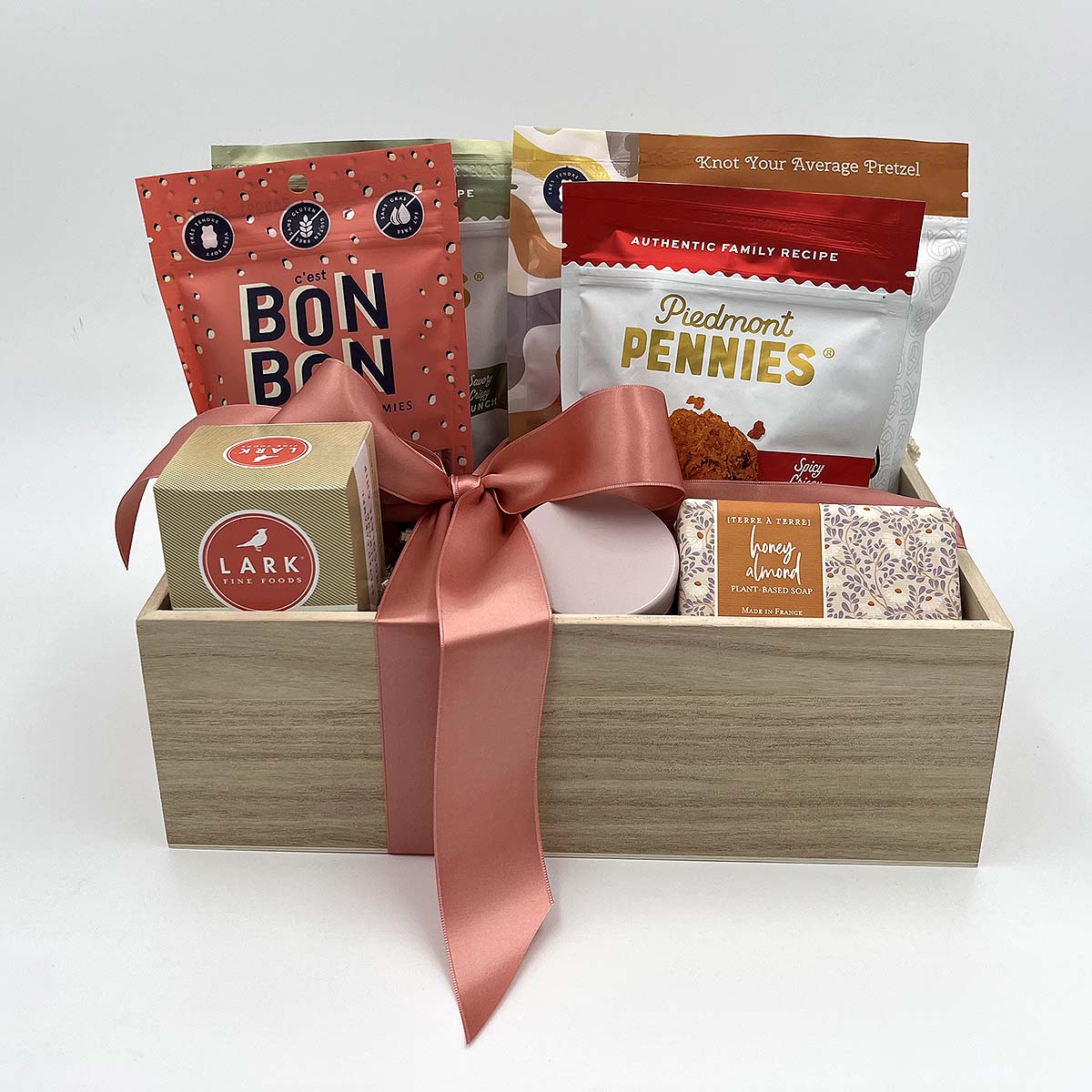 Gourmet gift basket with artisanal snacks, sweets, soap, candle, and matches