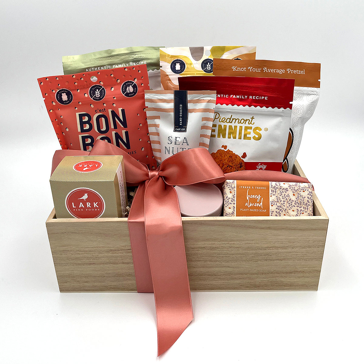 Gourmet gift basket with artisanal snacks, sweets, soap and a candle.