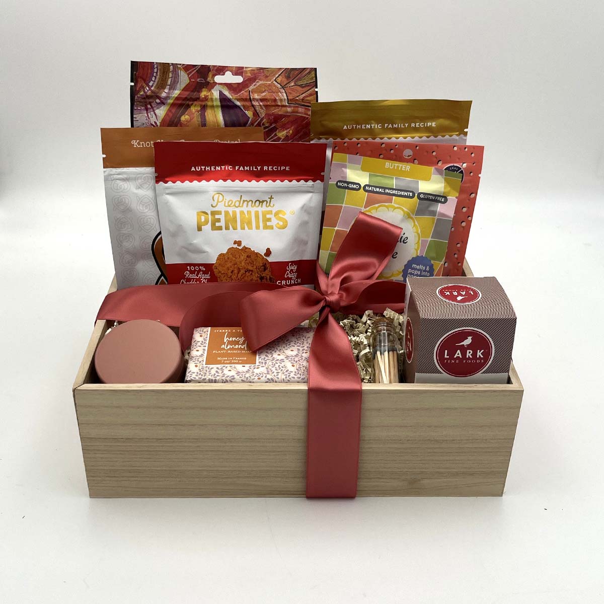 Gourmet gift basket with artisanal snacks, sweets, soap, candle, and matches