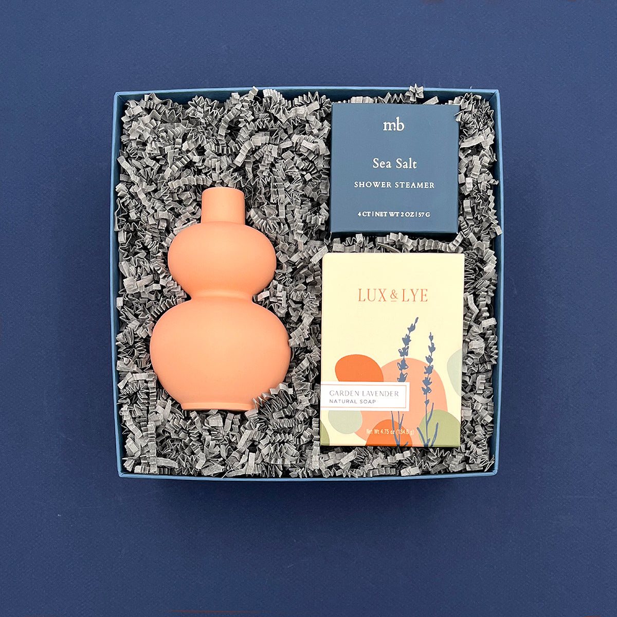 Self-care gift box featuring a coral double-gourd vase, handcrafted lavender soap, and sea salt shower steamer.
