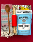 Overhead view of the Christmas Cookie Gift Box with baking mix, sprinkles, towel, rolling pin, and cookie cutter.