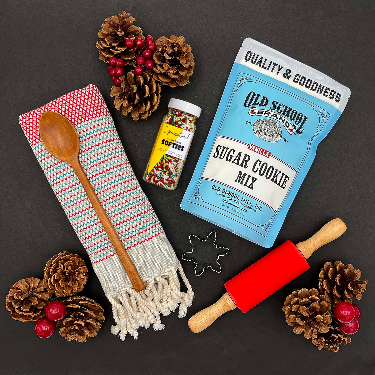 Snowflake cookie cutter, rolling pin, and wood spoon included in the Christmas Cookie baking gift set.