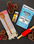 Snowflake cookie cutter, rolling pin, and wood spoon included in the Christmas Cookie baking gift set.