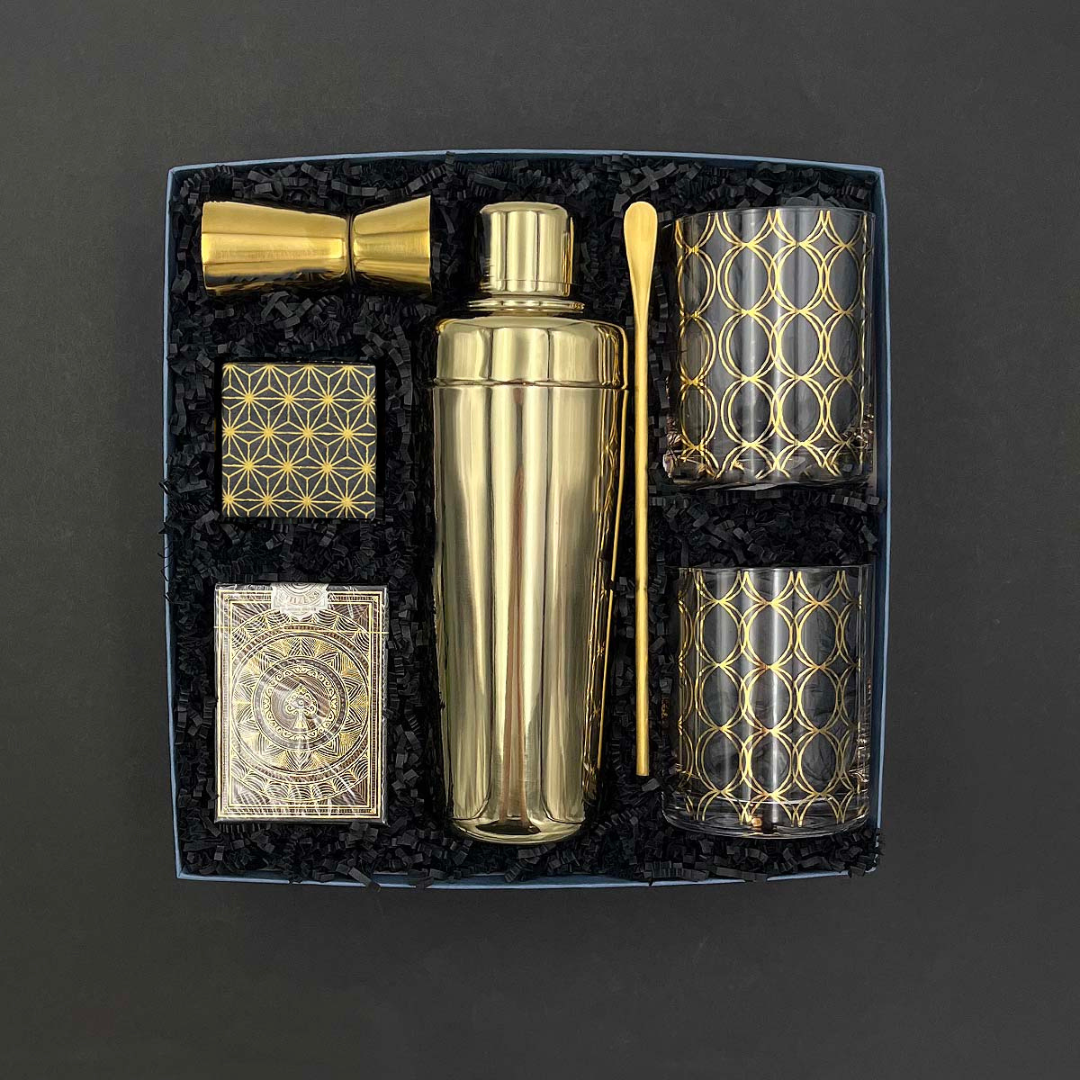 Five O’Clock Gift Box with gold cocktail shaker, lowball glasses, jigger, bar spoon, playing cards.