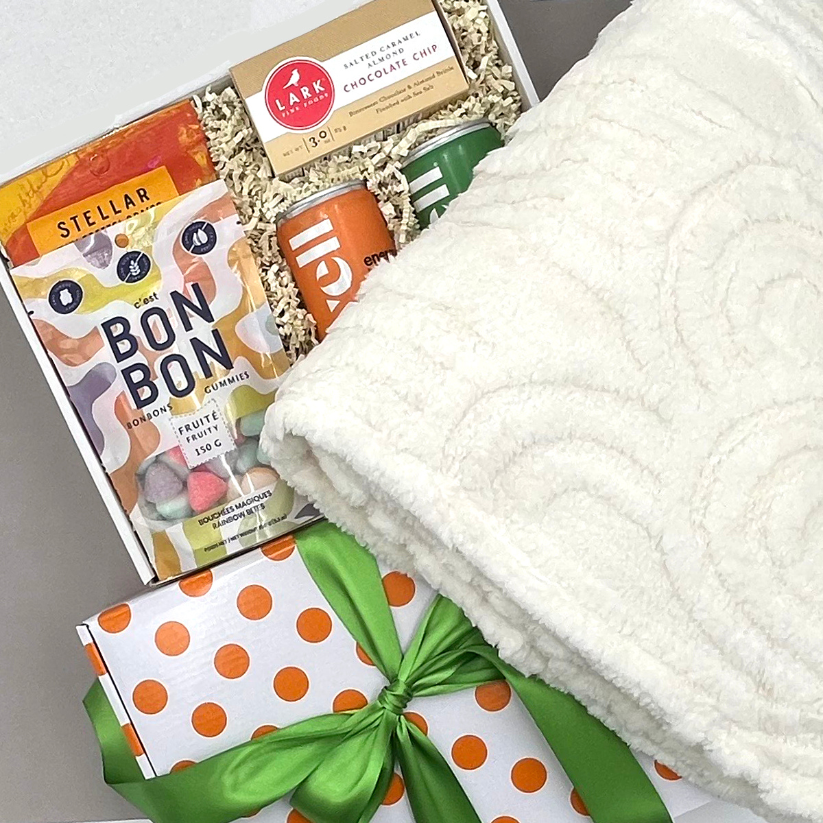 Care Package with snacks and a blanket on a gray surface