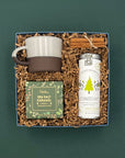 Overhead view of The Fraser Gift Box with chai tea, holiday cookies, ceramic mug, and cinnamon sticks.
