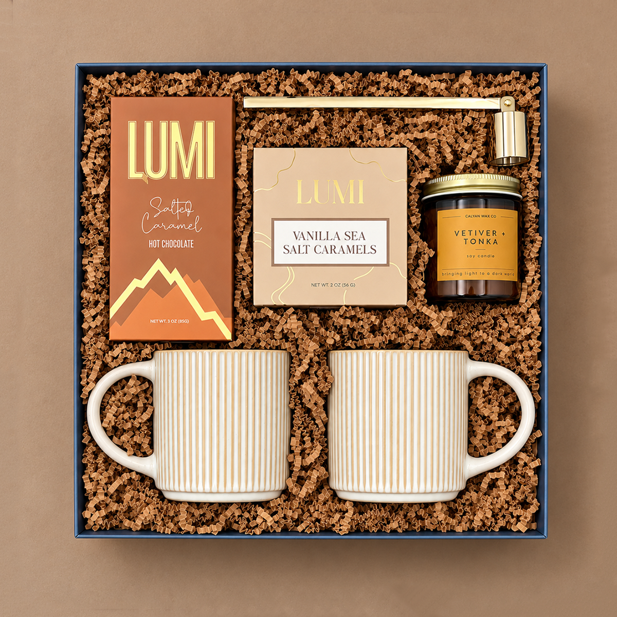 Hearth cozy gift box with stoneware mugs, salted caramel hot chocolate, vanilla sea salt caramels, candle, and gold candle snuffer.