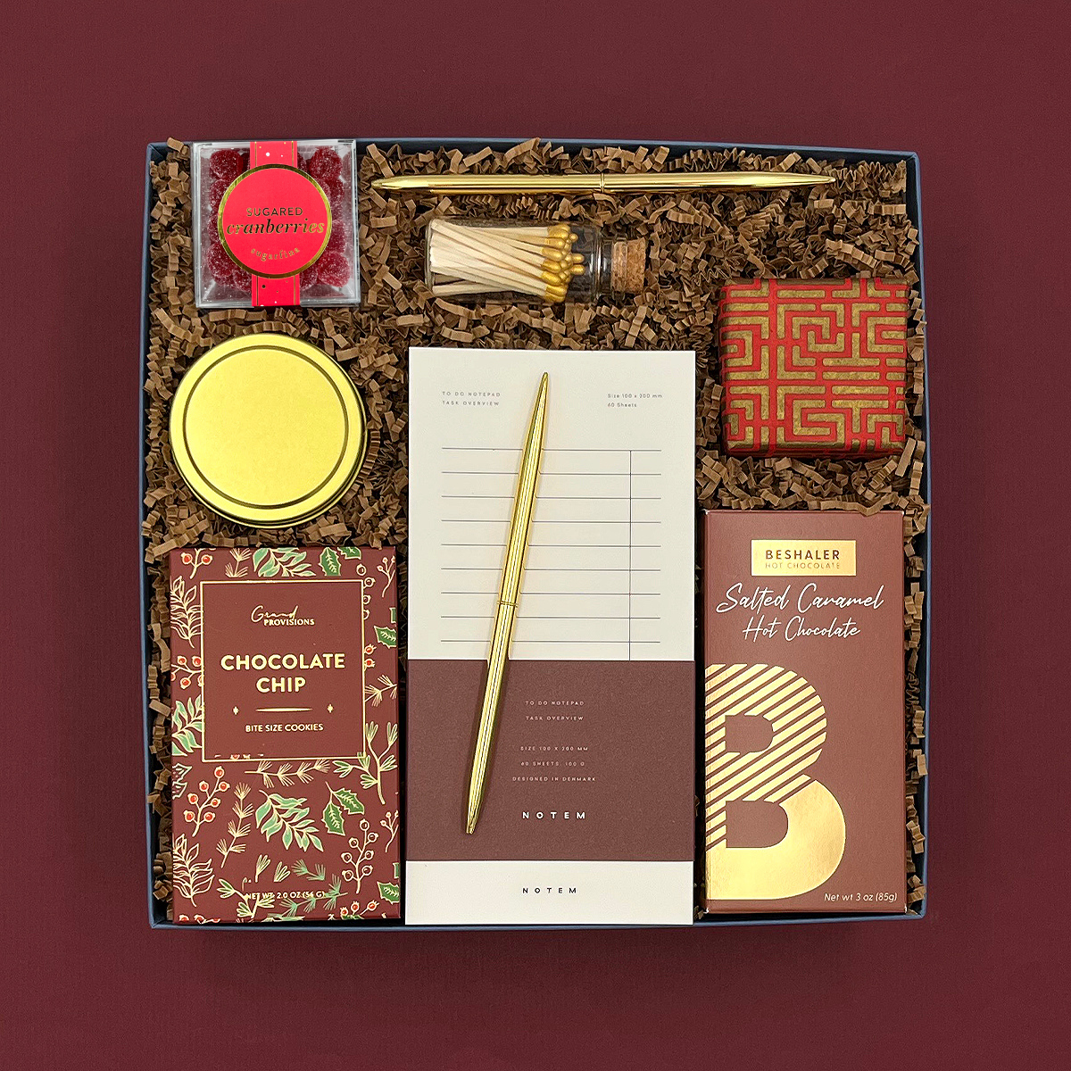 Hearth Gift Box filled with gourmet treats, cozy candle, and festive holiday accents.