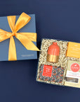 Just Because gift box with coral and gold bud vase, orange spice soap, shower steamer, and salted caramel almond chocolate chip cookies in a Thoughty box with gold ribbon,