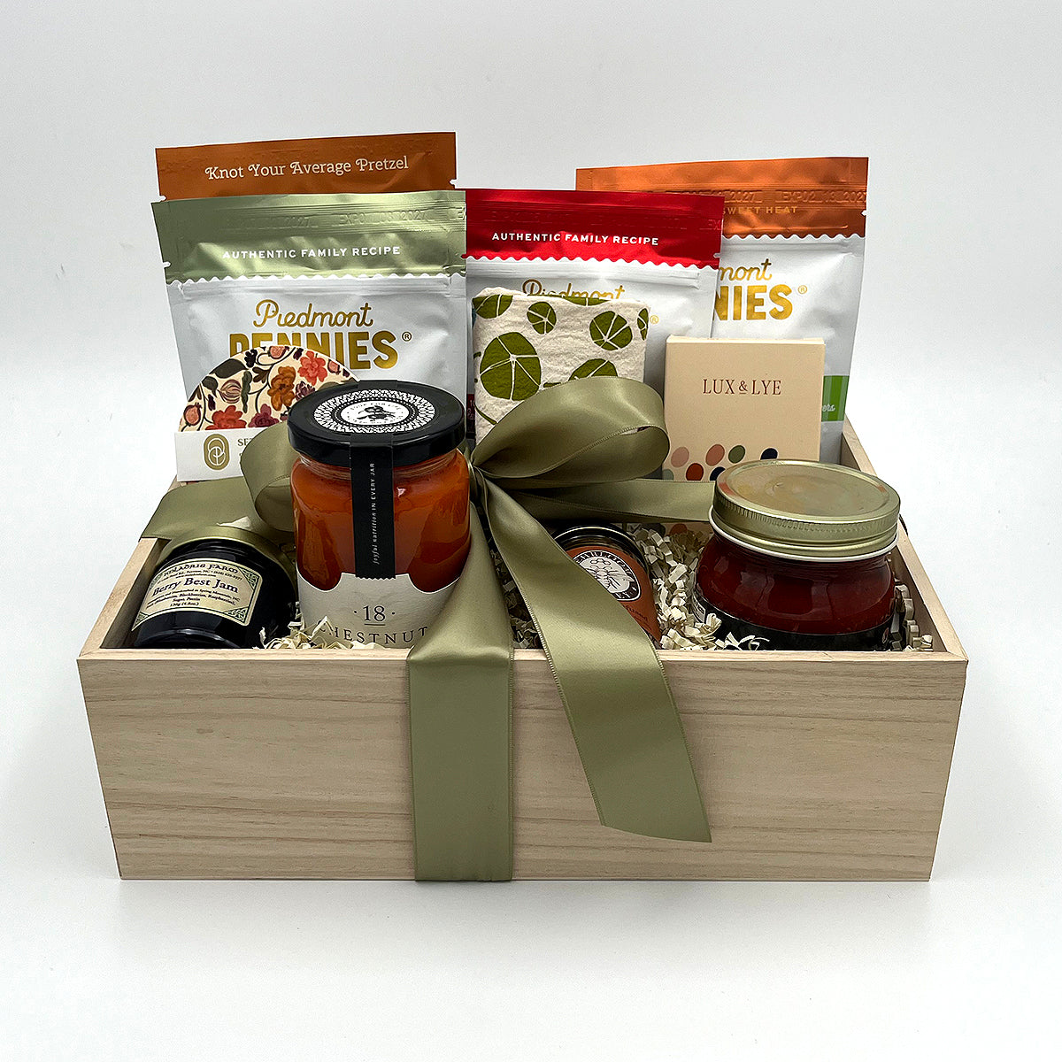 Made in NC Gift Crate with Queen City Crunch Pretzels, tomato soup, Piedmont Pennies cheese bites, honey, hand soap, marinara, jam, and kitchen towel.