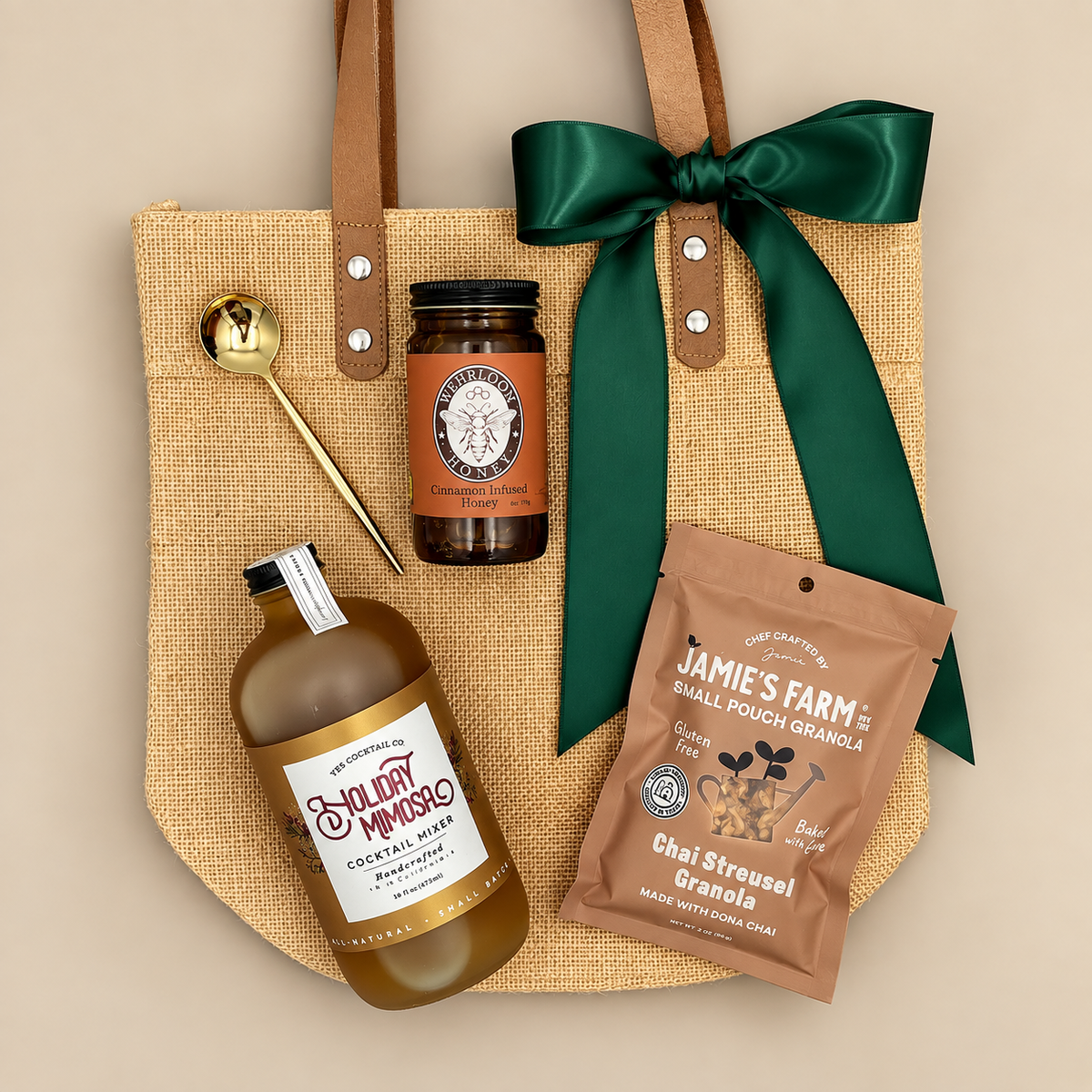 Merry Morning holiday gift tote with chai granola, cinnamon infused honey, gold spoon, and festive mimosa mixer.