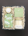 Self-care gift box featuring relaxing candle, shower steamer, nourishing lip balm, and gourmet cookies.