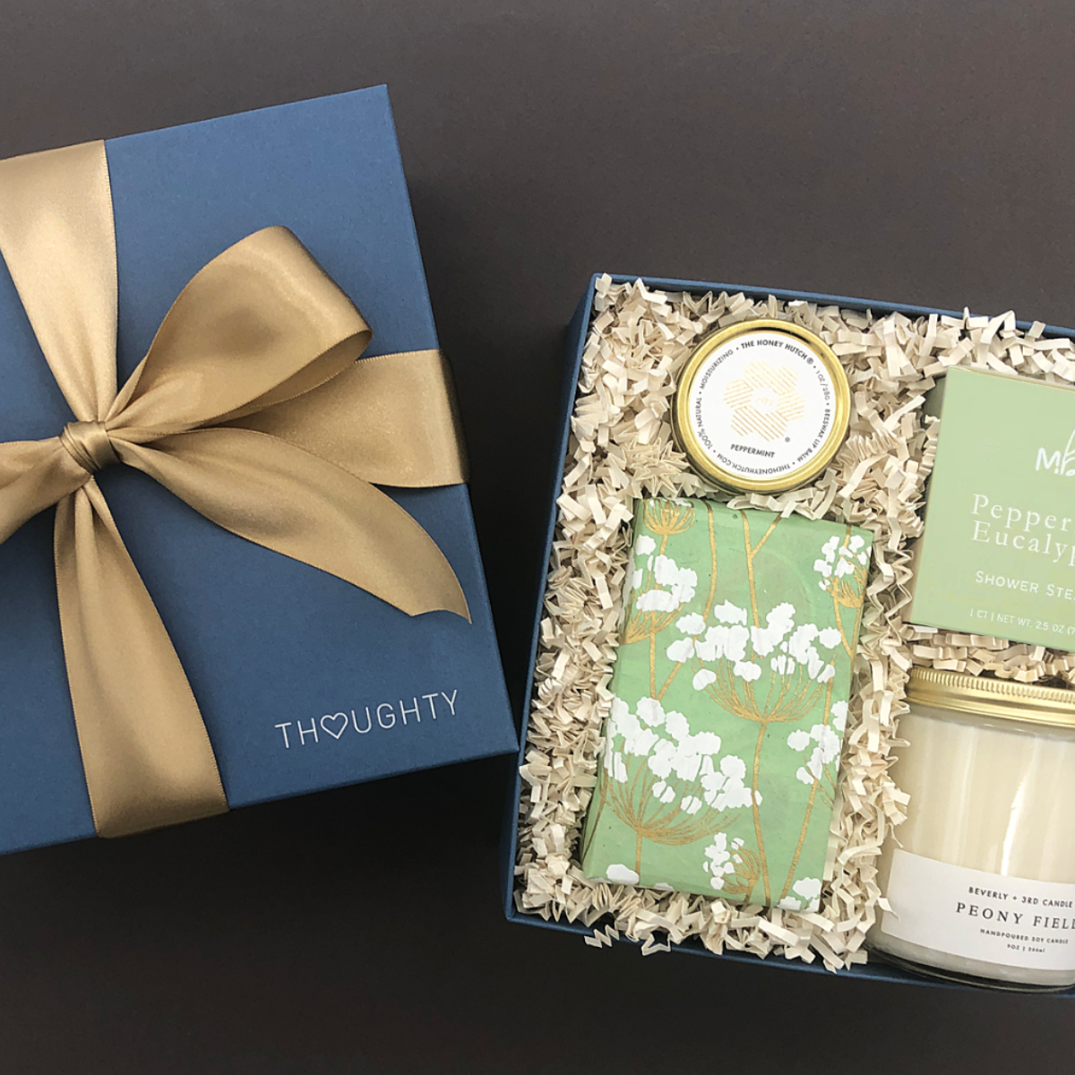 Mindful Moment Gift Box with Peony Fields candle, lavender shower steamer, peppermint lip balm, and salted caramel almond cookies.