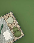 Green ceramic items on a textured surface with a green background