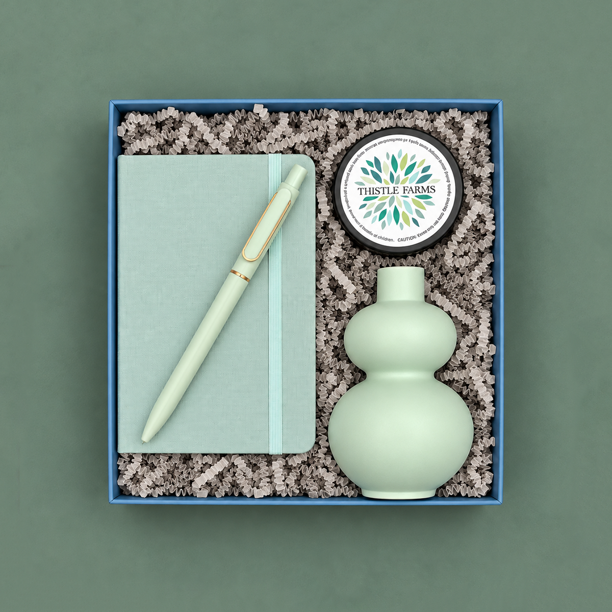 Noted gift box with mint notebook and pen, mint double-gourd bud vase, and Thistle Farms eucalyptus mint body butter.