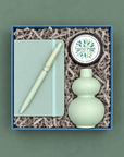 Noted gift box with mint notebook and pen, mint double-gourd bud vase, and Thistle Farms eucalyptus mint body butter.