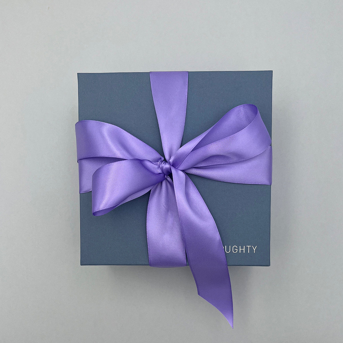 Blue gift box with a purple ribbon on a light gray background