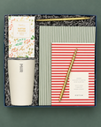 Season’s Greetings holiday gift box with white MiiR tumbler, butter toffee pretzels, notebooks, and gold pens.