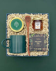 Tea Time Gift Box with holiday tea, green mug, honey, candle, and satin ribbon.