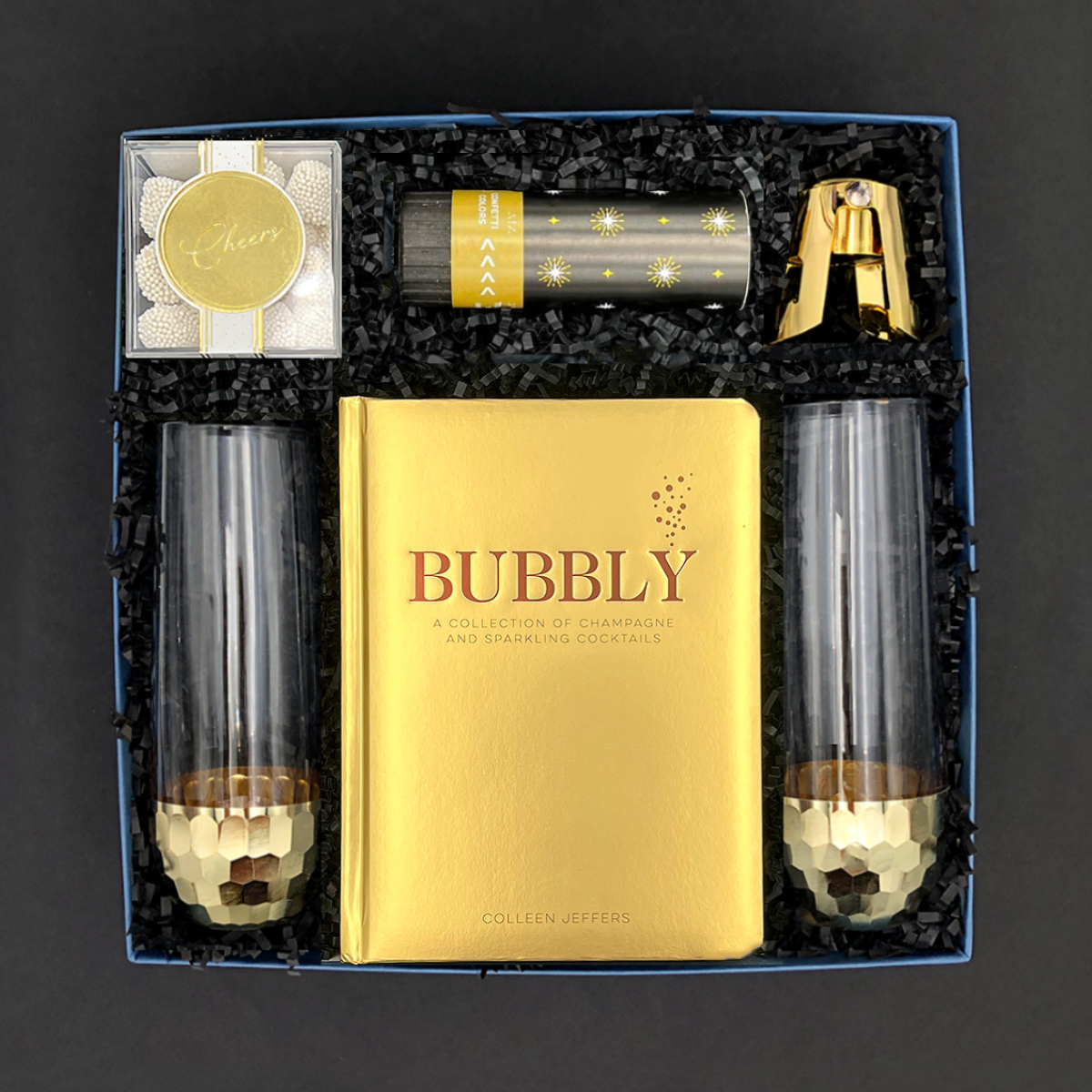 Elegant black and gold celebration gift set with champagne treats and confetti popper.