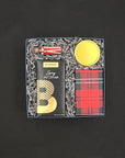 Gift set with spicy hot chocolate, ginger snap cookies, snow and pine candle and peppermint stick matches on a dark background