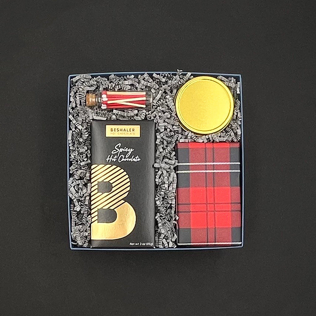 Overhead view of the Warm Wishes Gift Box with hot chocolate, cookies, candle, and peppermint stick matches arranged inside.