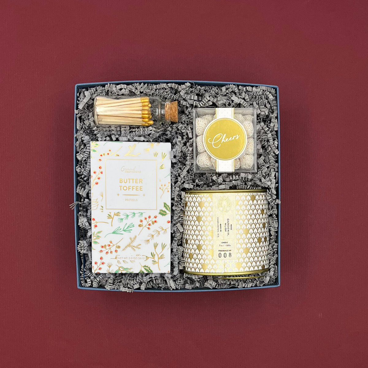Winter White Gift Box with candle, pretzels, Champagne gummies, and gold accents.