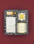 Winter White Gift Box with candle, pretzels, Champagne gummies, and gold accents.